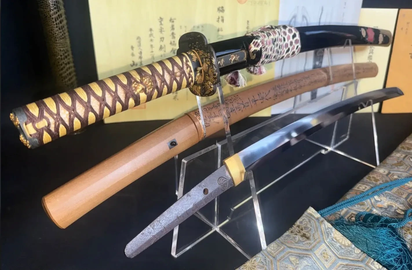 Japanese katana displayed with ornate koshirae, wooden shirasaya, polished blade and Japanese documentation